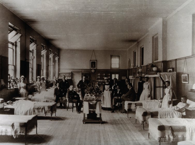 A scene in a 19th century hospital ward, in black and white.