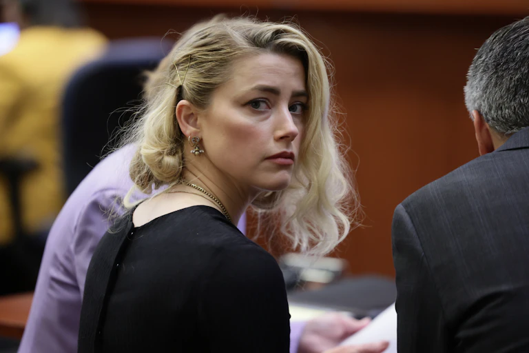 Amber Heard looks sadly over her shoulder in court