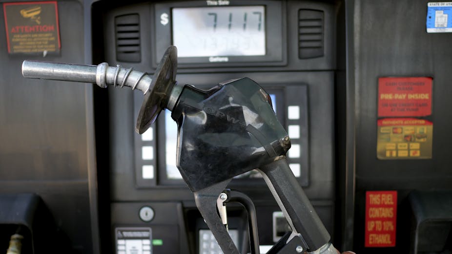 A gas nozzle is held up by a pump that has the price of $71.17 listed