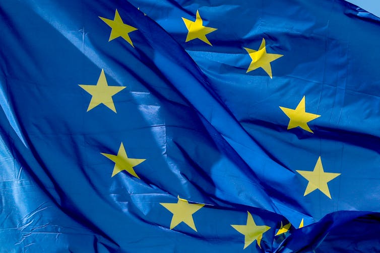 A EU flag waves in front of the European Council.
