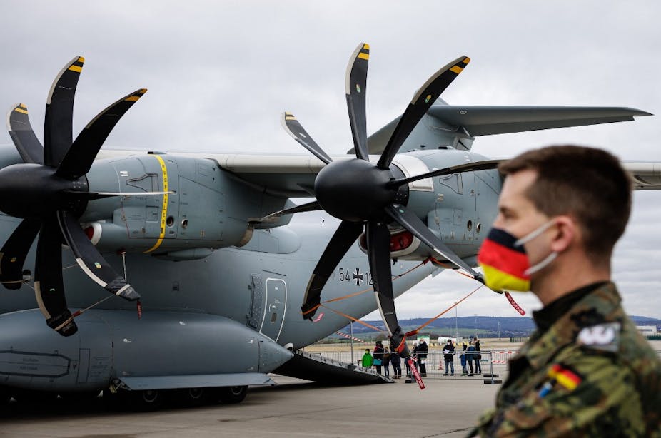 Un soldat des forces armées allemandes surveille l'embarcation  d'un avion-cargo de la Bundeswehr, un Airbus A400M.