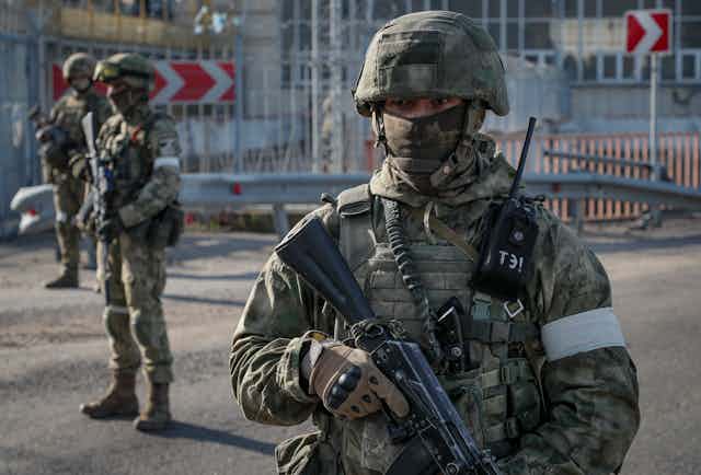 Russian soldiers on guard outside the  Kakhovka Hydroelectric Power Plant (HPP) on the Dnieper River in Kakhovka, near Kherson, May 2022.