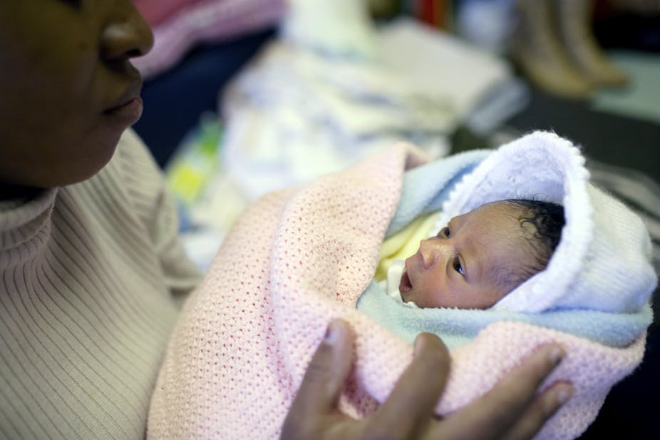 a woman holding a newborn baby