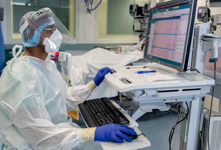 Hospital clinician entering data into a computer