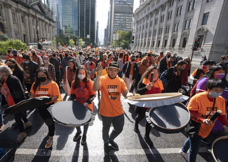 Une foule de manifestants portant un chandail orange