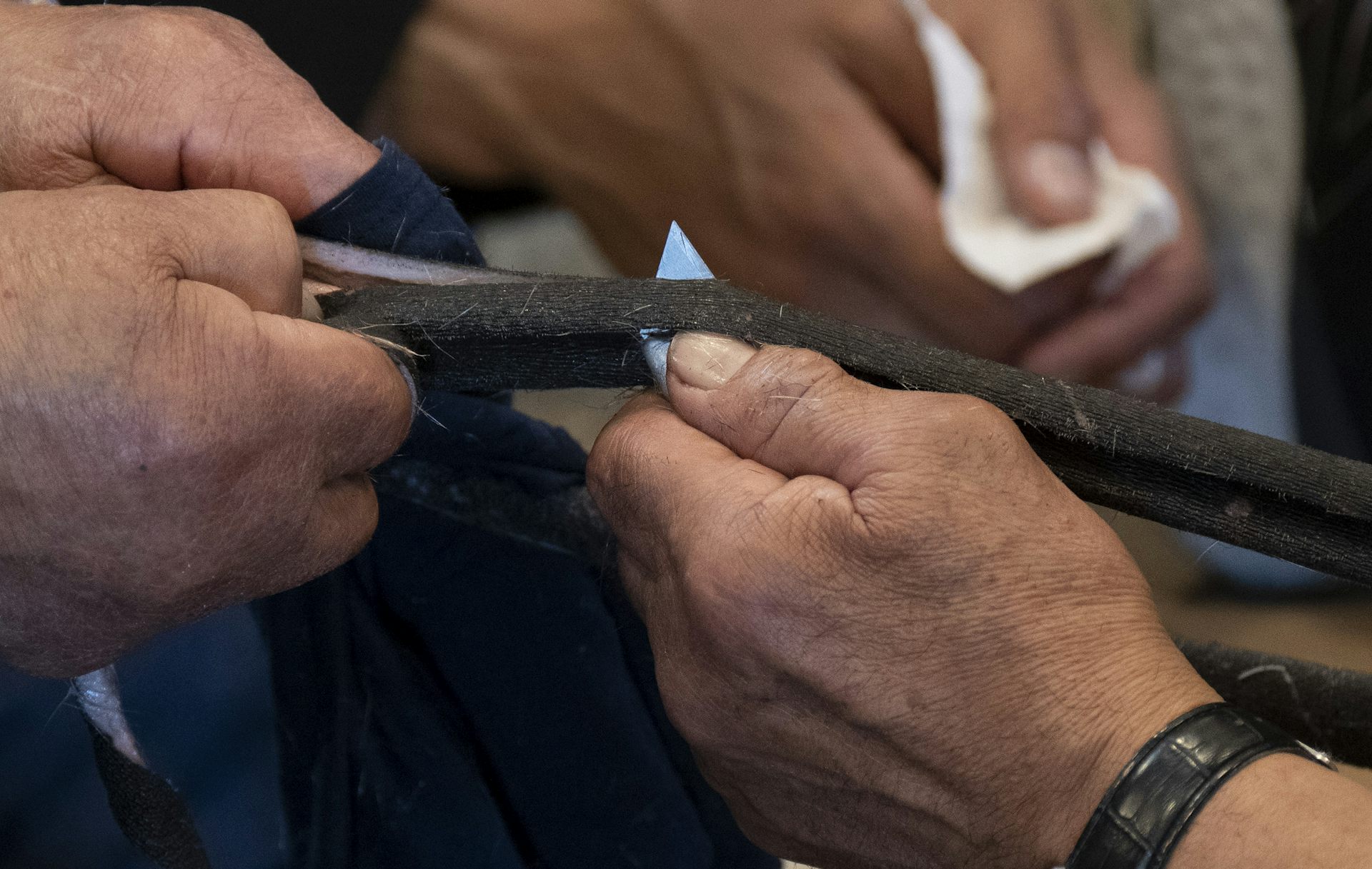Des mains d'hommes en train de travailler un bout de corde