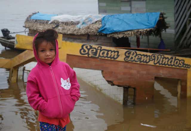 petite fille devant un quai qui se jette dans une rivière