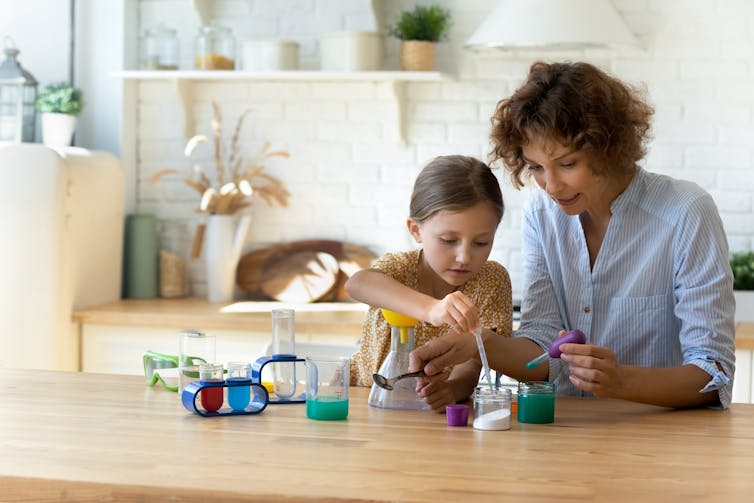 A mother and daughter do a science experiment in the kitchen
