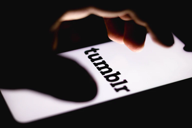 Fingers hover over bright white screen of smartphone.