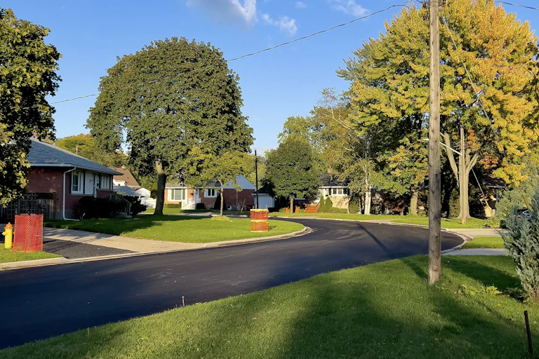 An image of a suburban street with tree lined streets