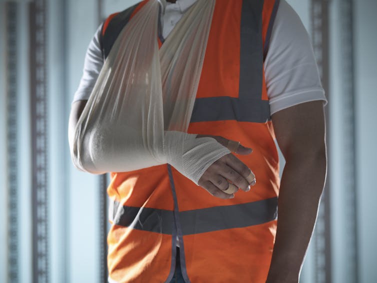 Injured worker in high visible vest.