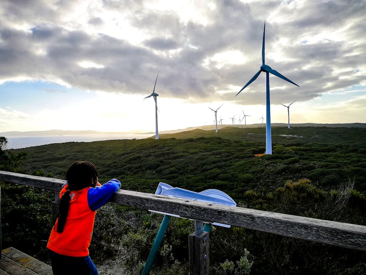 girl looks at wind turbines
