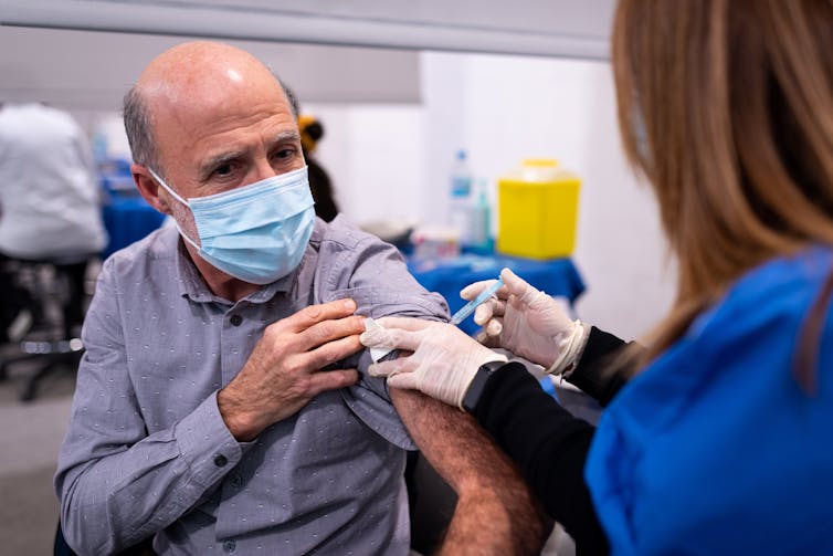 Nurse vaccinated older man in a facemask