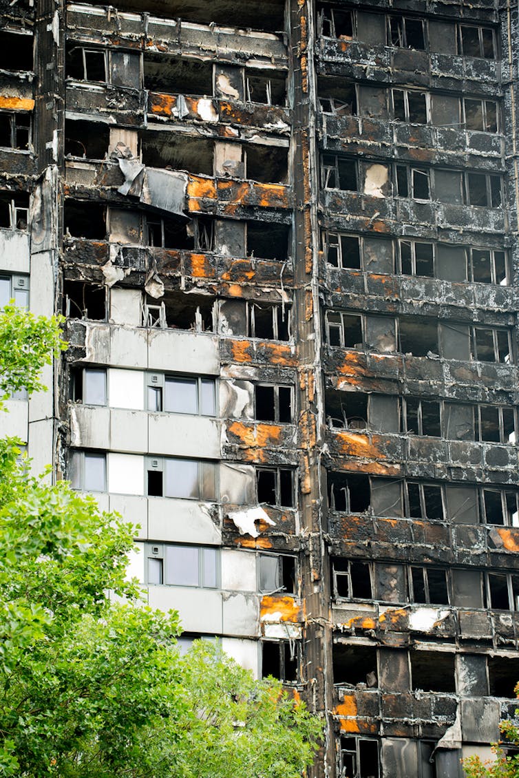 A detailed shot of a burnt high-rise building with some cladding still intact.
