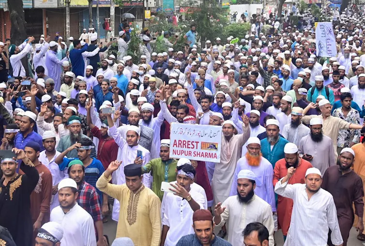 Foule d’hommes brandissant une pancarte « Arrêtez Nupur Sharma »
