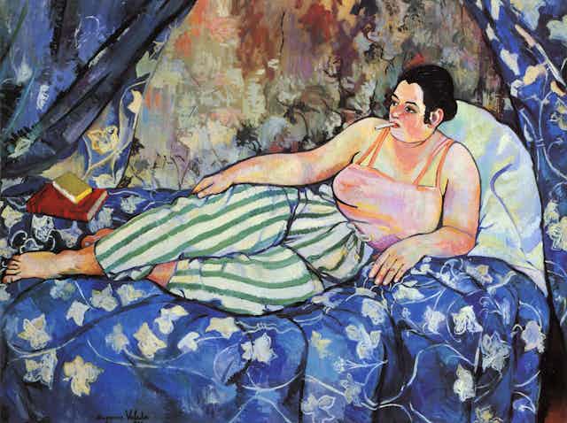 Painting of a woman reclining on a bed with books.