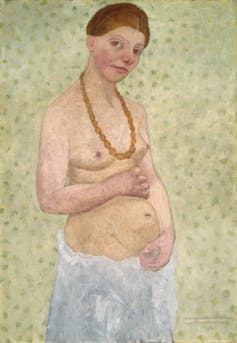 Pregnant woman holds baby, top half exposed.