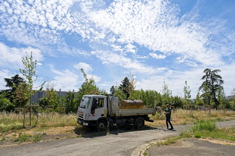 Personne arrosant des espaces verts avec de l’eau collectée d’une patinoire