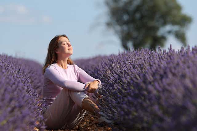 Woman taking in scent of a field of lavender.