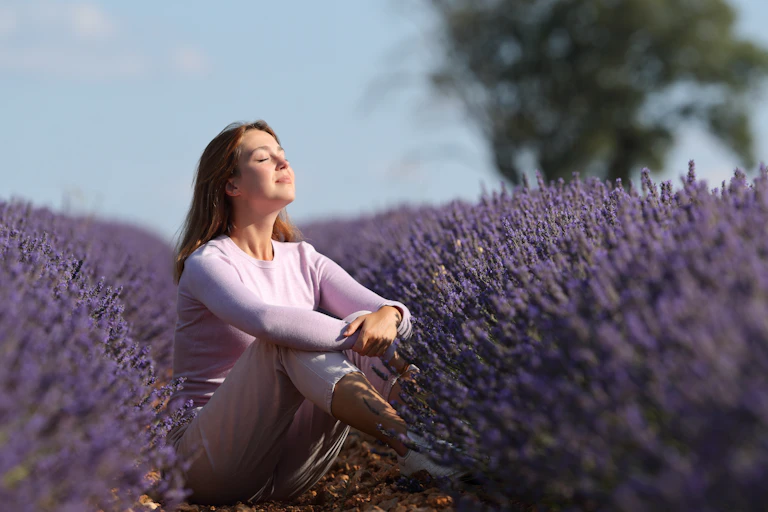 Woman taking in scent of a field of lavender.