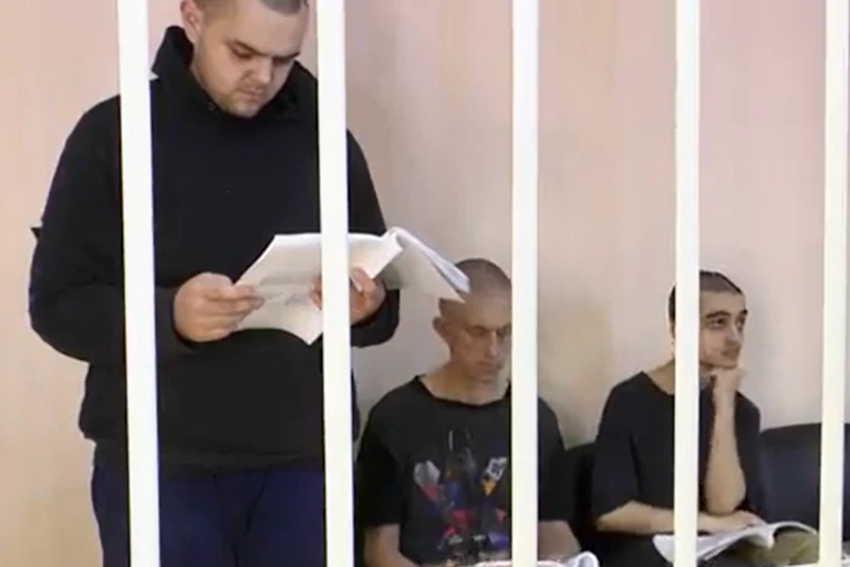 Trois hommes derrière des barreaux