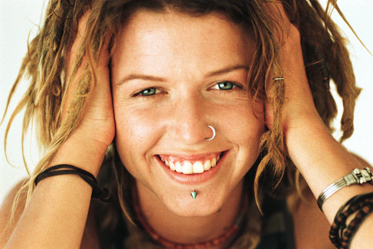 A photograph of a young woman wearing nose and chin jewelry.