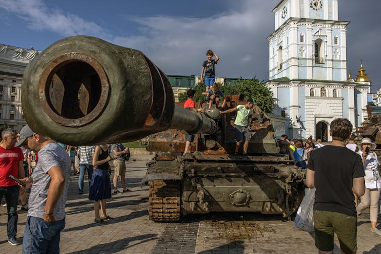 Boys climb on a Russian tank which was destroyed in fights with the Ukrainian army, displayed at Mykhailivskyi Square, in Kyiv, Ukraine, 12 June 2022.