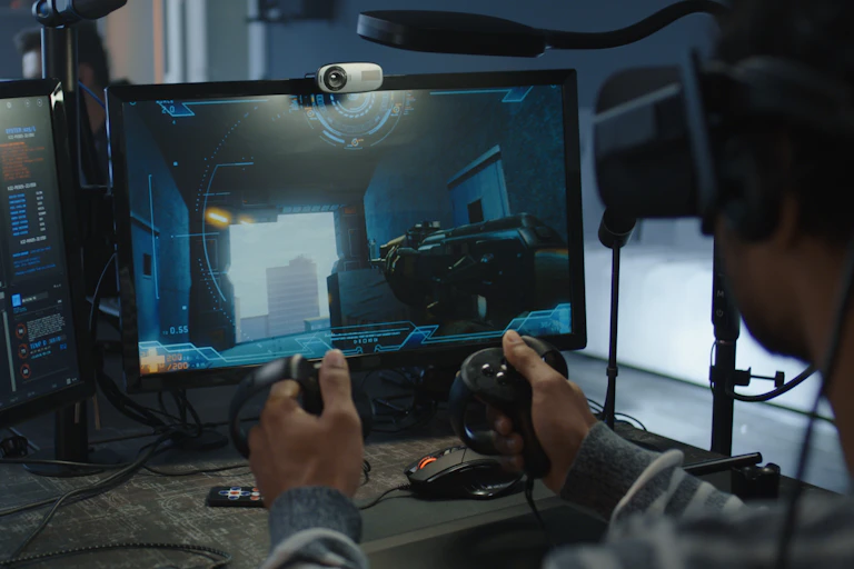 A person in a VR helmet playing a video game on a computer