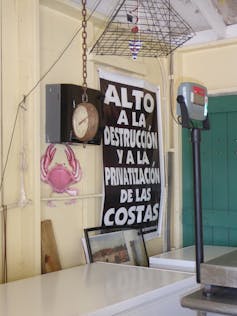 Protest poster in Spanish on a wall in a small local market