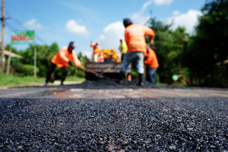 Men working on a road in high visibility clothing.