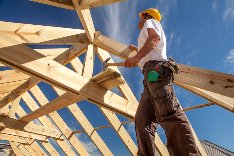 Roofer working on house being built.
