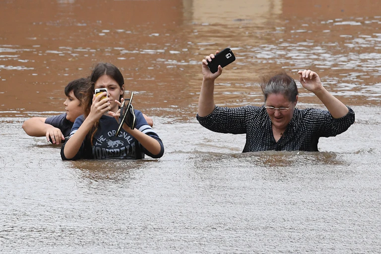 Family walks through deep flood waters