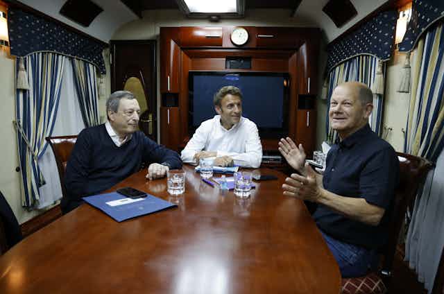 Italian Prime Minister Mario Draghi, French President Emmanuel Macron and German Chancellor Olaf Scholz talk inside a train carriage June 2022.
