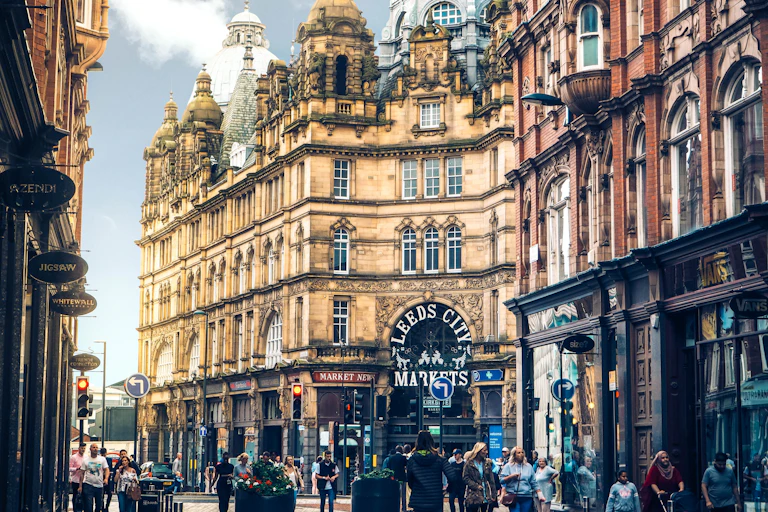 A street view with old buildings and pedestrians.