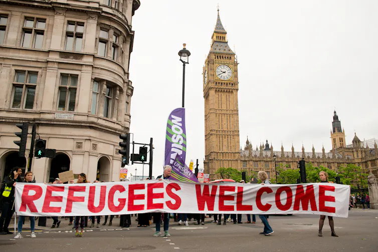 Protestors hold up a banner in a street.