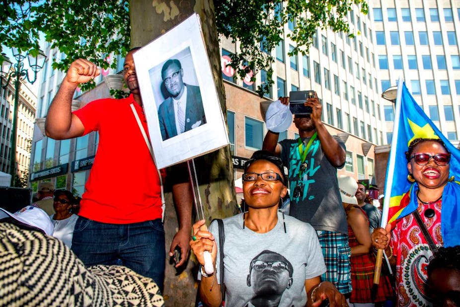 A protestor holds a picture of Patrice Lumumba.