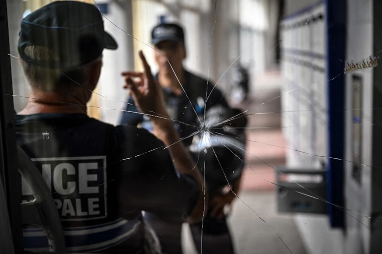 Deux policiers discutent devant une vitre brisée à Lyon La Duchère le 15 juin 2022