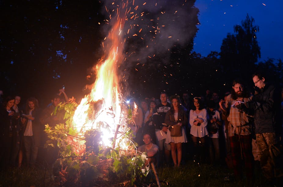 People gathered around a blazing fire for summer solstice celebrations.
