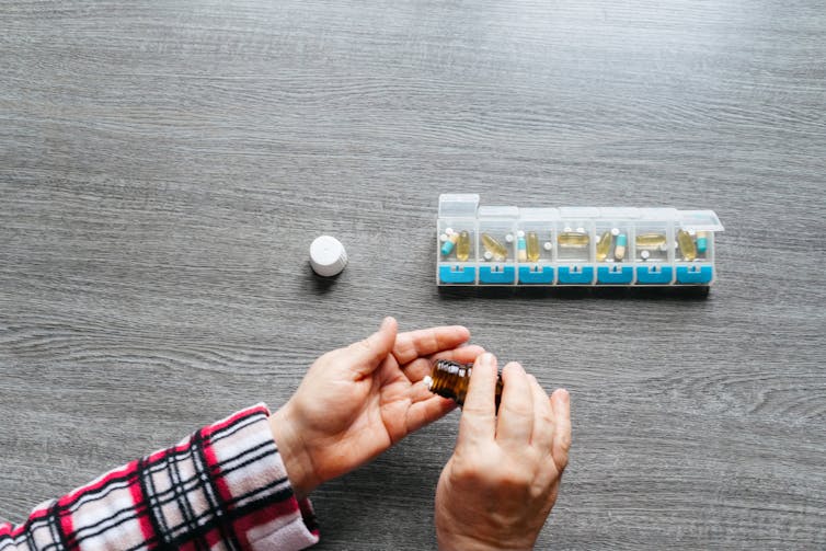 Person taking out pills from pill box