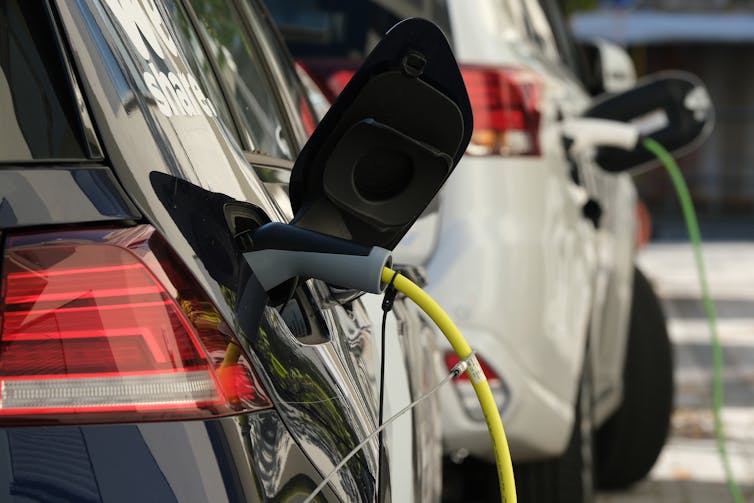 Two EVs being charged in a driveway