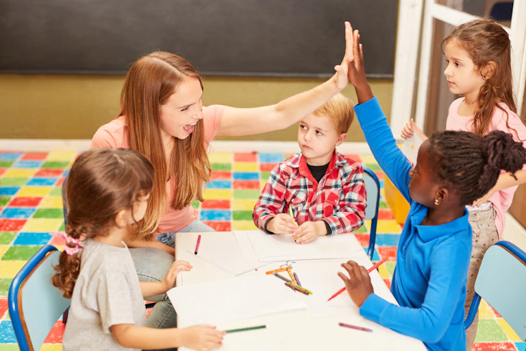 Preschool teacher high-fives one of the children