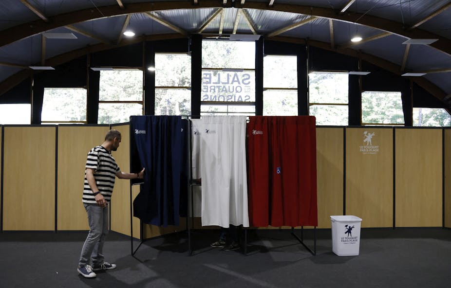 Un électeur entre dans l'isoloir pour voter pour les élections législatives françaises dans un bureau de vote du Touquet,  le 12 juin 2022.