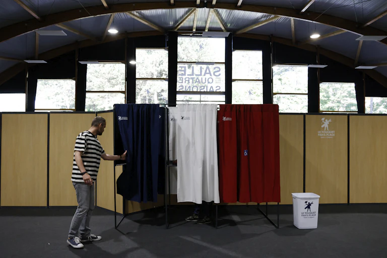 Un électeur entre dans l'isoloir pour voter pour les élections législatives françaises dans un bureau de vote du Touquet, le 12 juin 2022.