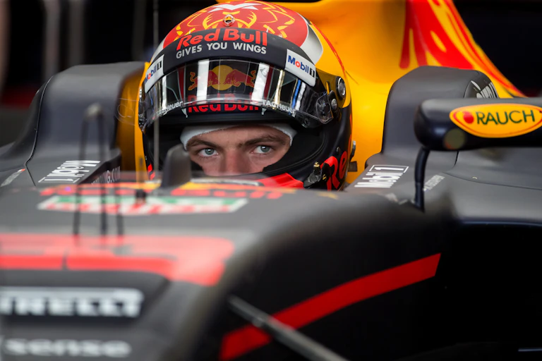 Gros plan sur un pilote de formule 1, casqué, assis dans son cockpit.