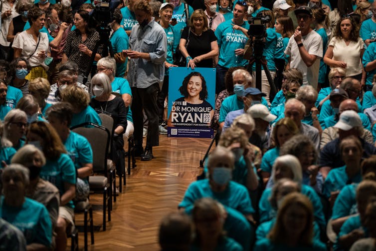 Monique Ryan poster in crowd wearing teal