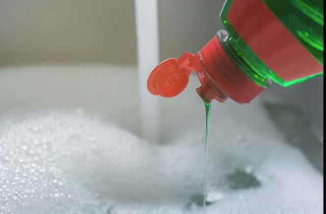 dishwashing soap drips into bubbles 