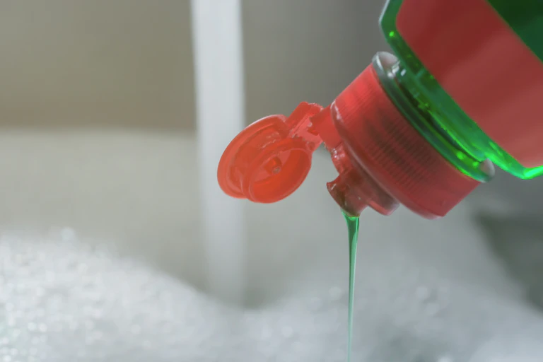dishwashing soap drips into bubbles