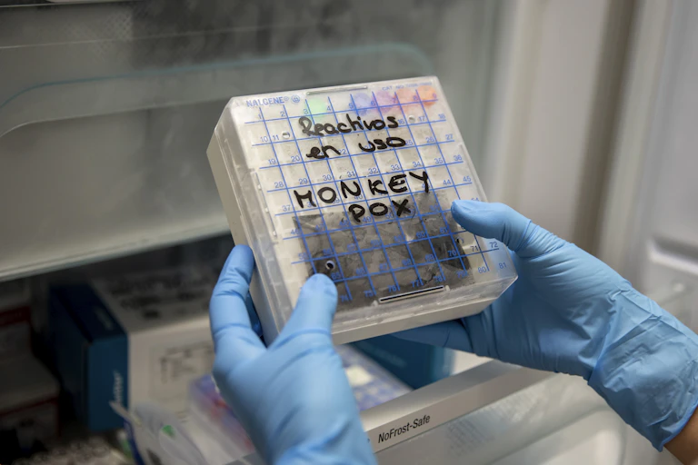 hands in gloves holding a testing kit in a lab