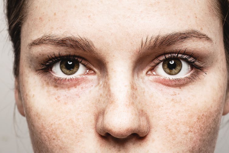 Close up of the top half of a young woman's face, she has brown eyes