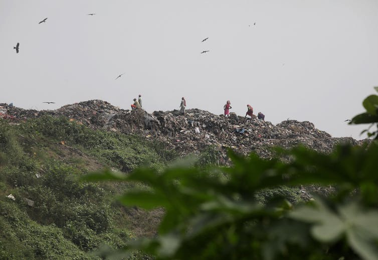 People pick through a mountain of waste.